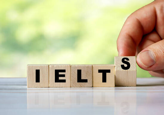 The hand turns the wooden cube and word IELTS